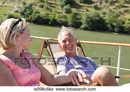 Senior couple sitting on deckchairs on a boat View Large Photo Image Stock Photo - Senior couple sitting on deckchairs on a boat. Fotosearch
