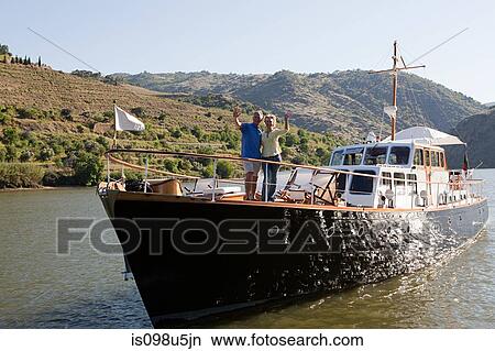Senior couple waving from a boat View Large Photo Image Picture - Senior couple waving from a boat. Fotosearch