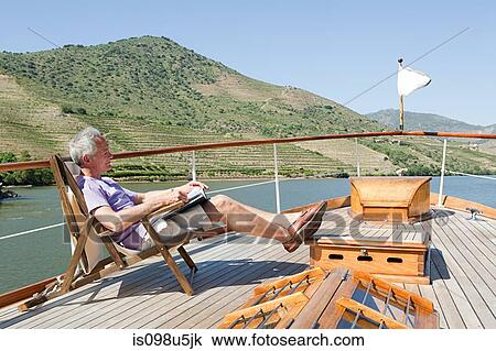 Senior man reading book on a boat holiday View Large Photo Image Stock Image - Senior man reading book on a boat holiday. Fotosearch