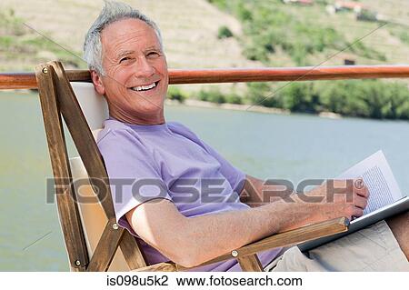 Senior man reading book on a boat holiday View Large Photo Image Stock Image - Senior man reading book on a boat holiday. Fotosearch