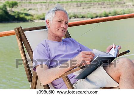 Senior man reading book on a boat holiday View Large Photo Image Stock Image - Senior man reading book on a boat holiday. Fotosearch