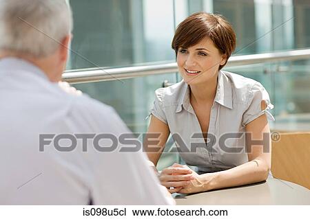Stock Image - Businesswoman and businessman talking. Fotosearch