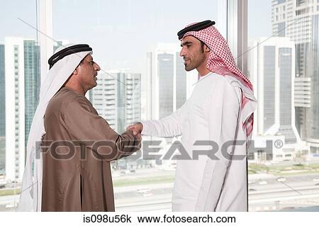 Dubai businessmen shaking hands by window View Large Photo Image Stock Image - Dubai businessmen shaking hands by window. Fotosearch