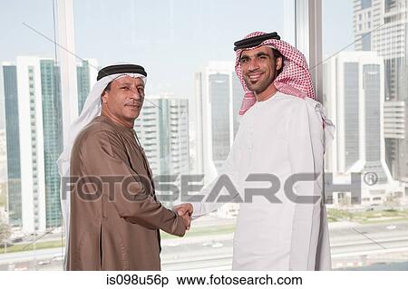 Dubai businessmen shaking hands by window View Large Photo Image Stock Photography - Dubai businessmen shaking hands by window. Fotosearch