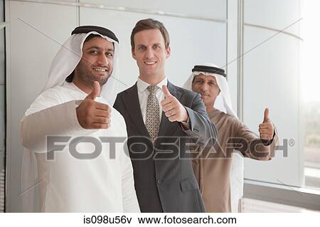 Middle eastern and western businessmen giving thumbs up View Large Photo Image Stock Photo - Middle eastern and western businessmen giving thumbs up. Fotosearch