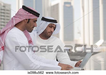 Middle eastern businessmen using laptop outdoors View Large Photo Image Stock Image - Middle eastern businessmen using laptop outdoors. Fotosearch