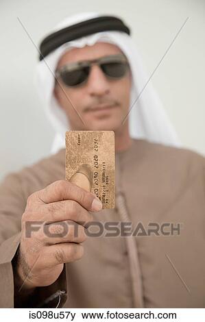 Middle eastern man holding credit card View Large Photo Image Stock Photo - Middle eastern man holding credit card. Fotosearch