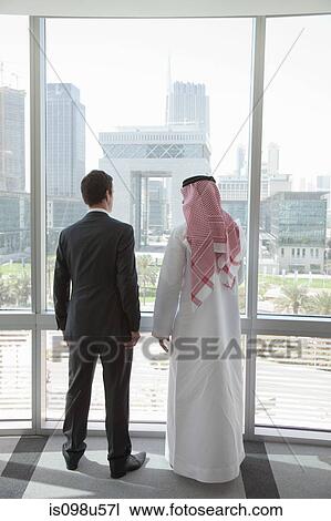Western and middle eastern businessmen by window of dubai office View Large Photo Image Stock Image - Western and middle eastern businessmen by window of dubai office. Fotosearch
