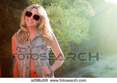 Portrait of young woman wearing sunglasses View Large Photo Image Stock Photo - Portrait of young woman wearing sunglasses. Fotosearch