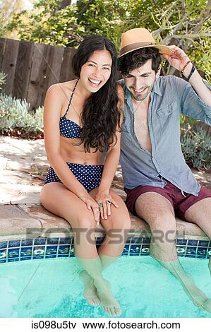 Stock Photo - Young couple in swimming pool on vacation. Fotosearch