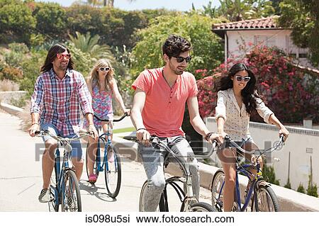 Stock Image - Young friends on bicycles on vacation. Fotosearch