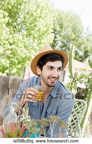 Stock Photography - Young man wearing throwing trilby. Fotosearch
