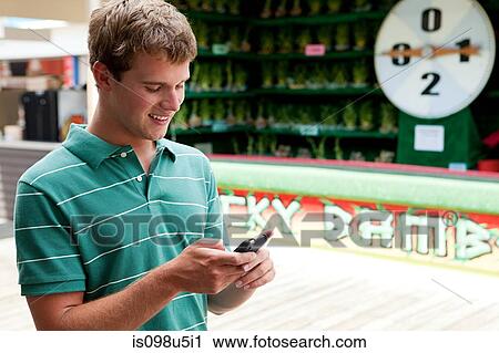 Teenage boy using cellphone at fun fair View Large Photo Image Stock Image - Teenage boy using cellphone at fun fair. Fotosearch