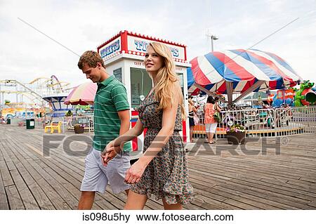 Stock Photo - Teenage couple at boardwalk fun fair. Fotosearch