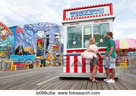 Teenage couple at fun fair ticket booth View Large Photo Image Stock Image - Teenage couple at fun fair ticket booth. Fotosearch