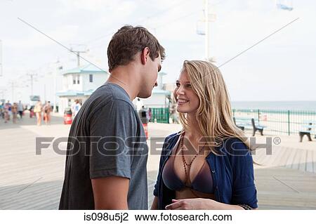 Teenage couple on boardwalk View Large Photo Image Stock Image - Teenage couple on boardwalk. Fotosearch