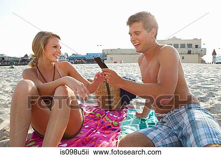 Teenage couple on the beach with cellphone View Large Photo Image Stock Image - Teenage couple on the beach with cellphone. Fotosearch