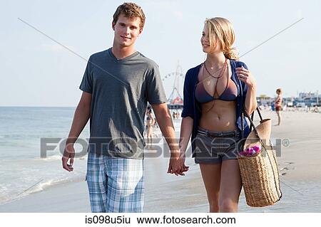 Teenage couple walking hand in hand on beach View Large Photo Image Stock Photograph - Teenage couple walking hand in hand on beach. Fotosearch