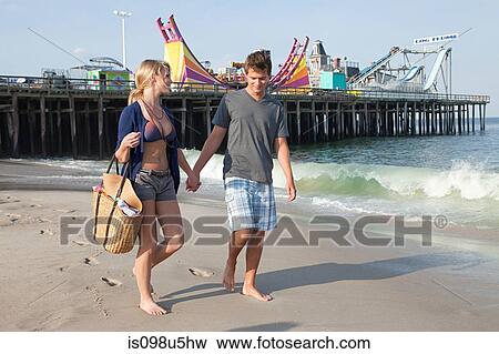 Teenage couple walking on beach View Large Photo Image Stock Photo - Teenage couple walking on beach. Fotosearch