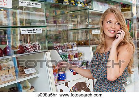 Teenage on cellphone by confectionery stand View Large Photo Image Stock Photography - Teenage on cellphone by confectionery stand. Fotosearch