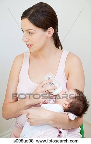 Mother bottle feeding baby View Large Photo Image Stock Photo - Mother bottle feeding baby. Fotosearch