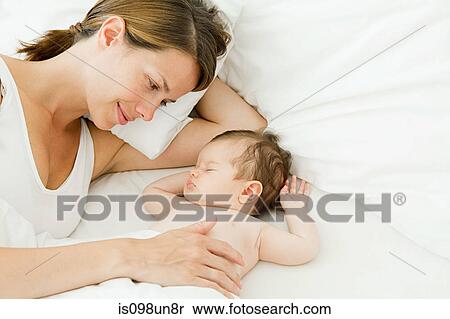 Stock Photography - Mother watching baby sleep. Fotosearch