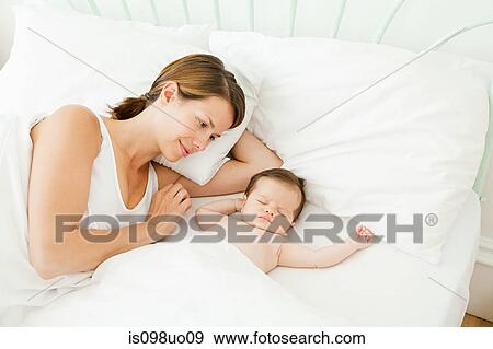 Mother watching baby sleeping View Large Photo Image Stock Photo - Mother watching baby sleeping. Fotosearch
