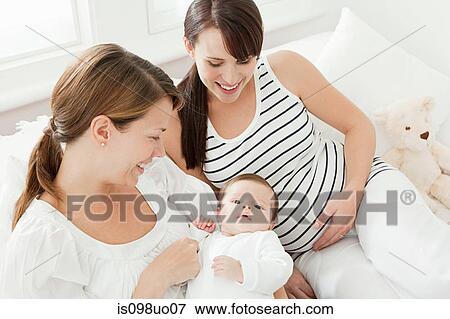 Mother with baby girl and pregnant friend View Large Photo Image Stock Photo - Mother with baby girl and pregnant friend. Fotosearch