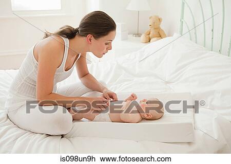 Mother with baby son on changing mat View Large Photo Image Stock Image - Mother with baby son on changing mat. Fotosearch