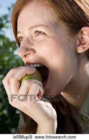Young woman eating apple View Large Photo Image Stock Image - Young woman eating apple. Fotosearch
