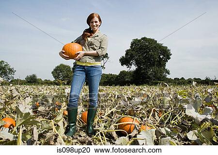 Young woman holding pumpkin View Large Photo Image Stock Image - Young woman holding pumpkin. Fotosearch