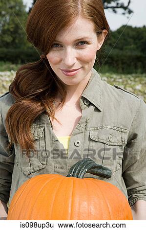 Young woman with a pumpkin View Large Photo Image Stock Photograph - Young woman with a pumpkin. Fotosearch