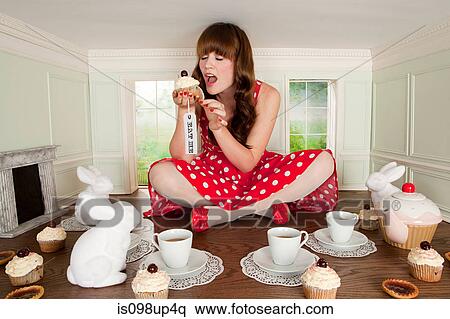 Young woman eating cake at tea party in small room View Large Photo Image Stock Photography - Young woman eating cake at tea party in small room. Fotosearch