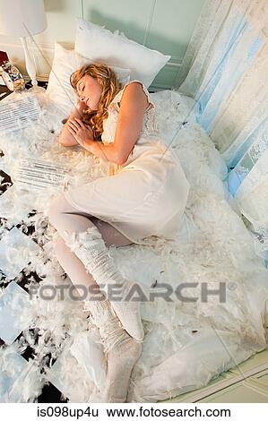 Young woman sleeping amongst pillow feathers View Large Photo Image Stock Photograph - Young woman sleeping amongst pillow feathers. Fotosearch