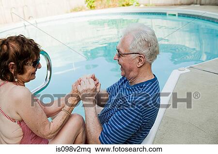Senior couple holding hands by swimming pool View Large Photo Image Stock Photography - Senior couple holding hands by swimming pool. Fotosearch