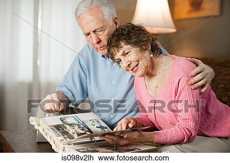 Senior couple looking at family album View Large Photo Image Stock Image - Senior couple looking at family album. Fotosearch