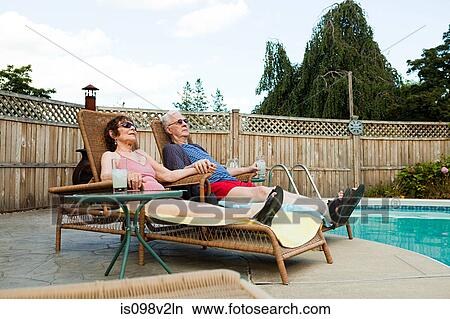 Senior couple relaxing by swimming pool View Large Photo Image Picture - Senior couple relaxing by swimming pool. Fotosearch