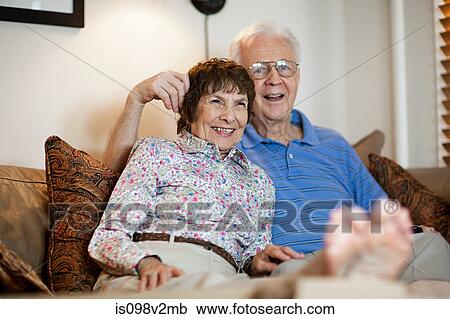 Stock Image - Senior couple watching tv at home. Fotosearch