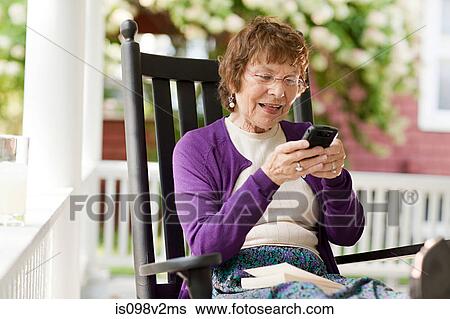 Stock Photograph - Senior woman using cellphone. Fotosearch