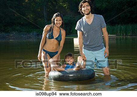 Couple and daughter at lake with inflatable ring View Large Photo Image Picture - Couple and daughter at lake with inflatable ring. Fotosearch