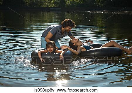 Stock Photo - Couple and daughter having fun in lake. Fotosearch