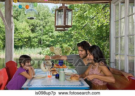 Family having breakfast together outdoors View Large Photo Image Stock Photography - Family having breakfast together outdoors. Fotosearch