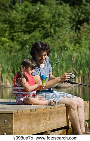 Picture - Father and daughter fishing from jetty. Fotosearch