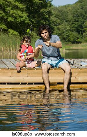 Stock Photography - Father and daughter fishing from jetty. Fotosearch