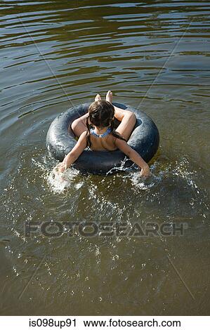 Girl on inflatable ring in lake View Large Photo Image Stock Image - Girl on inflatable ring in lake. Fotosearch