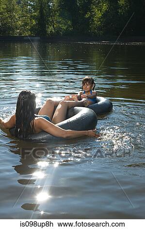 Mother and daughter in lake on inflatable rings View Large Photo Image Stock Image - Mother and daughter in lake on inflatable rings. Fotosearch