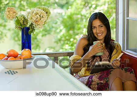 Woman relaxing with a drink and a book View Large Photo Image Stock Image - Woman relaxing with a drink and a book. Fotosearch