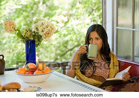 Woman relaxing with a drink and a book View Large Photo Image Stock Photograph - Woman relaxing with a drink and a book. Fotosearch