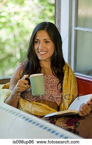 Woman relaxing with a drink and a book View Large Photo Image Stock Photograph - Woman relaxing with a drink and a book. Fotosearch