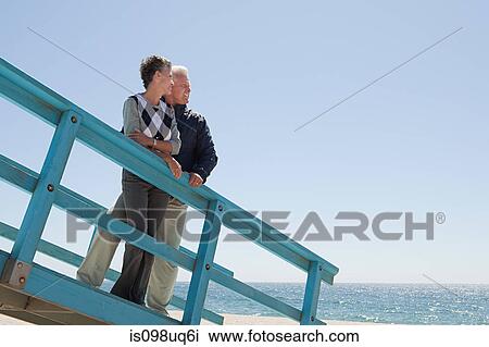 Mature couple on beach walkway View Large Photo Image Stock Image - Mature couple on beach walkway. Fotosearch